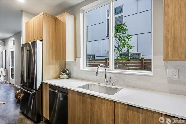 a kitchen with a sink a counter top space and stainless steel appliances