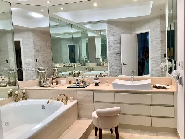 a bathroom with a tub sink and mirror