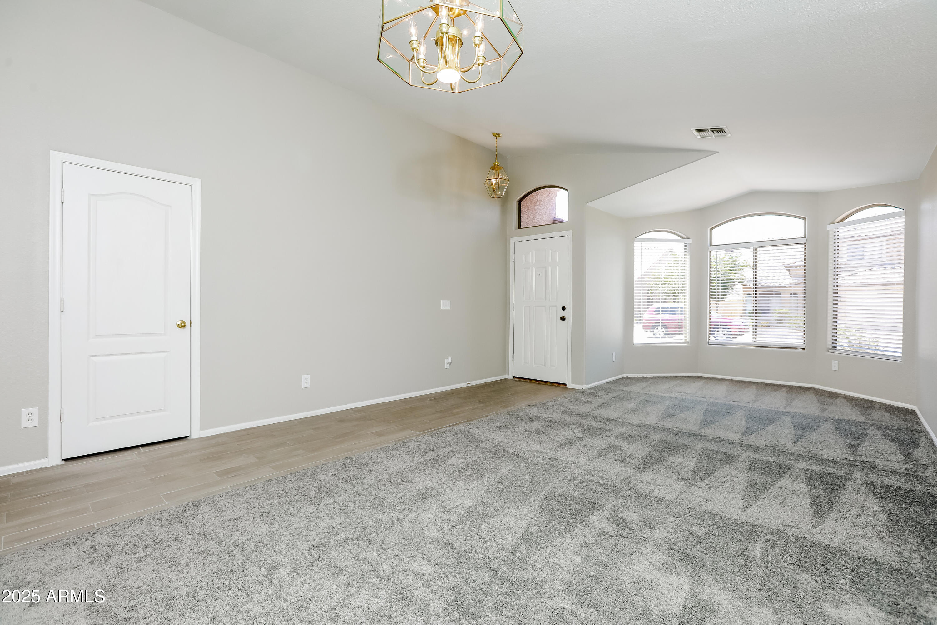 42430 Chambers Drive Maricopa, AZ 85138 - Photo 2 of 15 an empty room with windows and ceiling fan