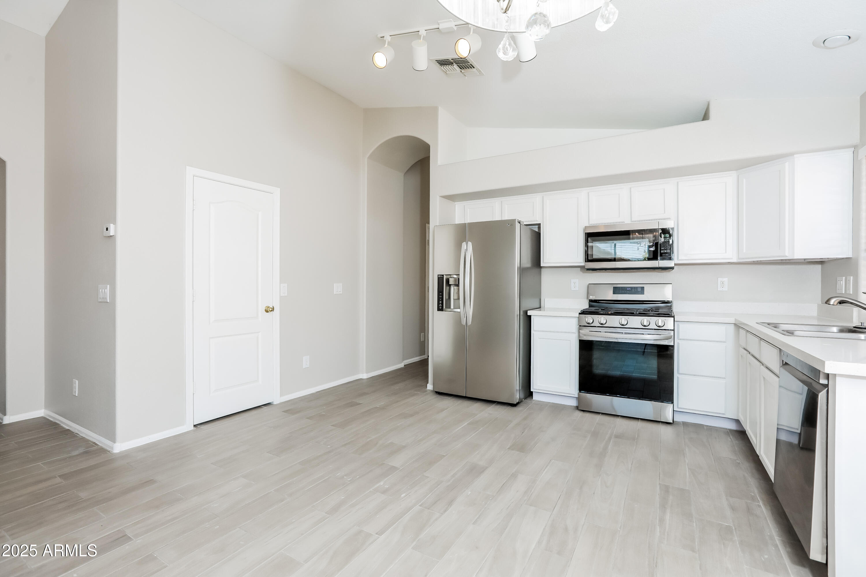 42430 Chambers Drive Maricopa, AZ 85138 - Photo 5 of 15 a kitchen with stainless steel appliances a refrigerator stove and microwave