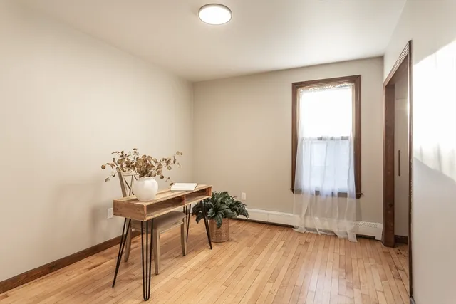 a view of a workspace with furniture and a window
