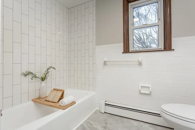 a bathroom with a tub a window and a shower