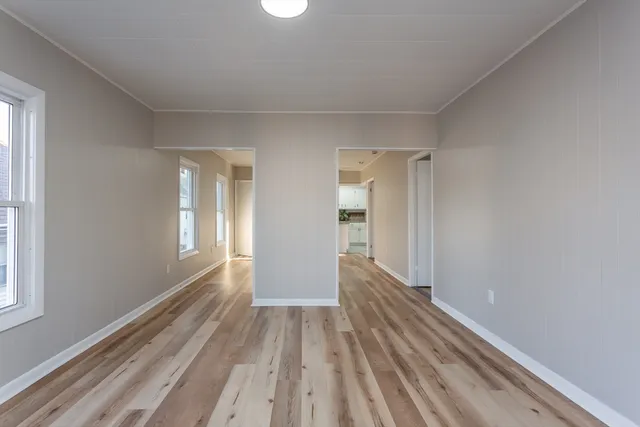 a view of a room with wooden floor and a window