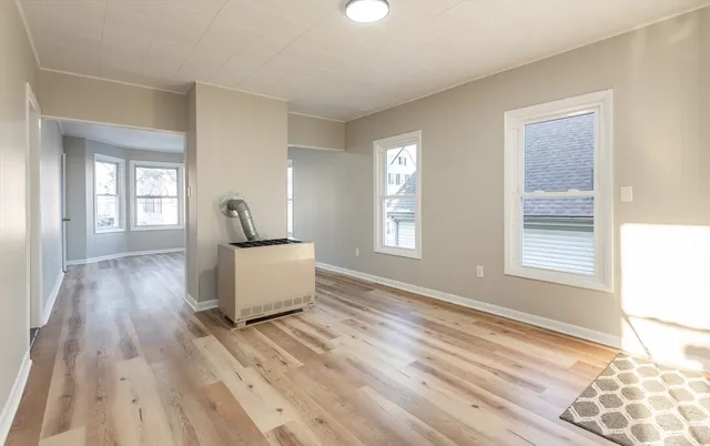 a living room with hard wood flooring and a window