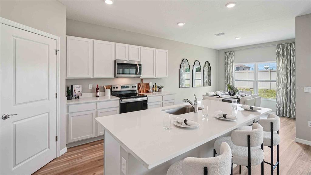 4623 Kona Circle Spring Hill, FL 34608 - Photo 3 of 25 a kitchen with white cabinets and stainless steel appliances