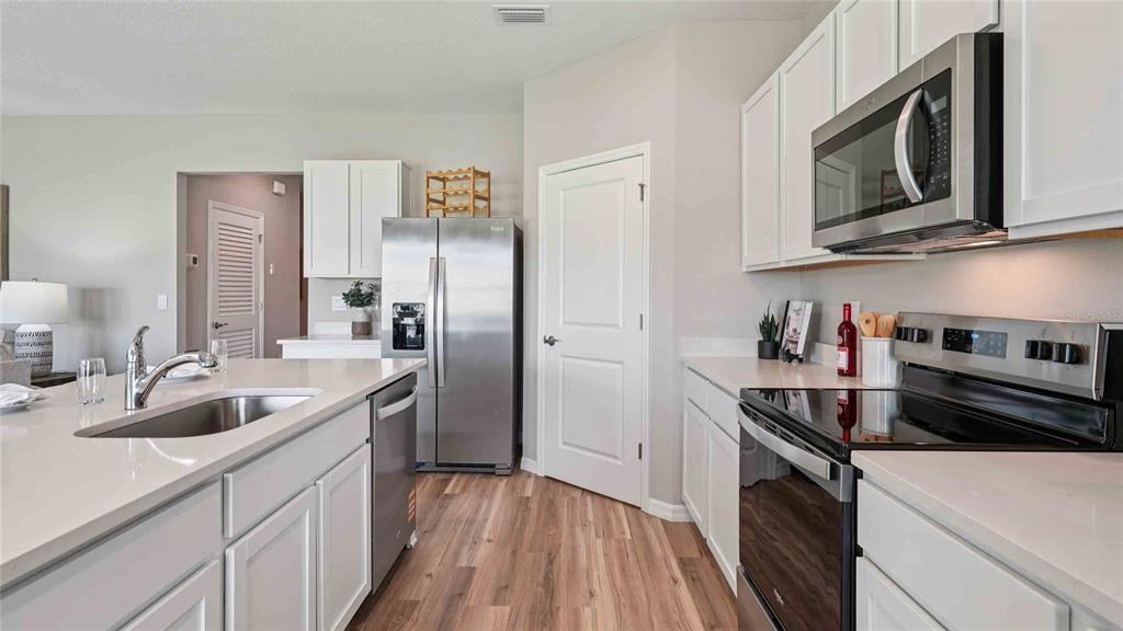 4623 Kona Circle Spring Hill, FL 34608 - Photo 6 of 25 a kitchen with stainless steel appliances granite countertop a sink stove and refrigerator