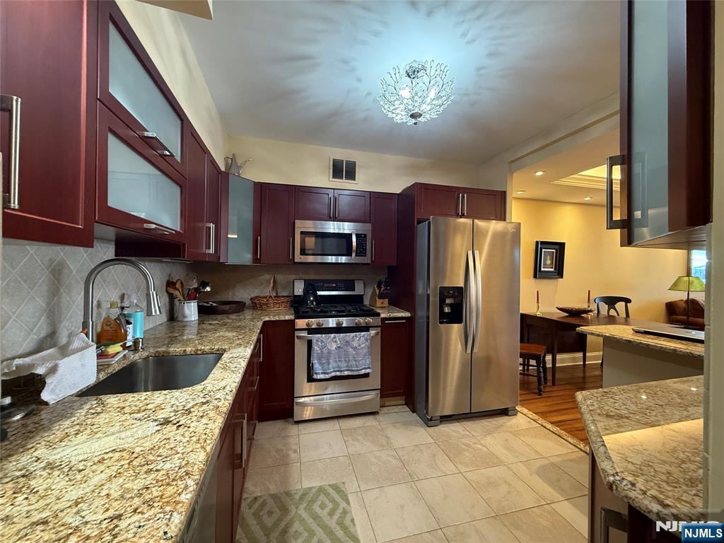 5 Horizon Road, Unit 2504 Fort Lee, NJ 07024 - Photo 13 of 41 a kitchen with stainless steel appliances granite countertop a refrigerator stove top oven a sink and dishwasher