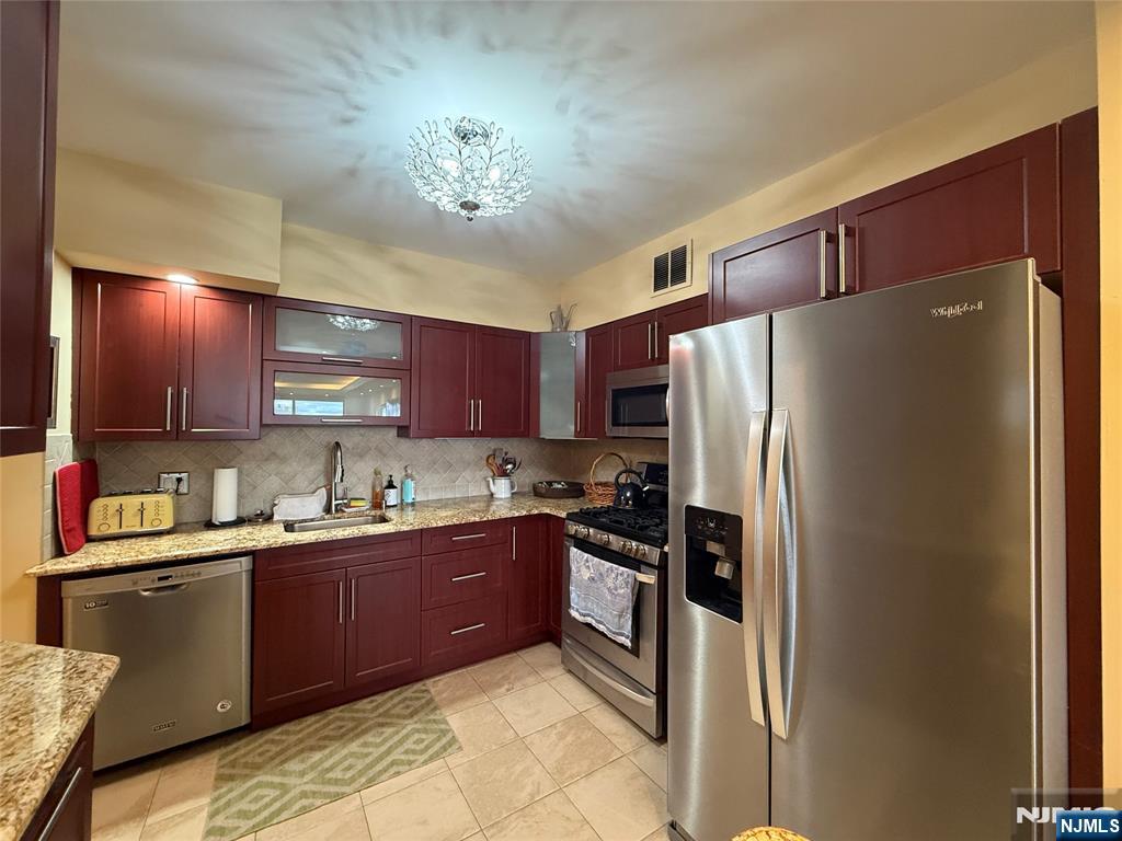 5 Horizon Road, Unit 2504 Fort Lee, NJ 07024 - Photo 15 of 41 a kitchen with stainless steel appliances granite countertop a refrigerator and a sink