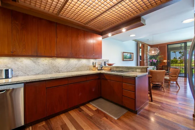 a kitchen with granite countertop wooden cabinets a sink and dishwasher