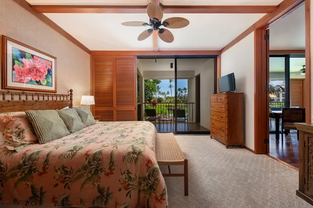 a spacious bedroom with a balcony a bed and a chandelier