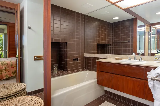 a bathroom with a tub sink and mirror