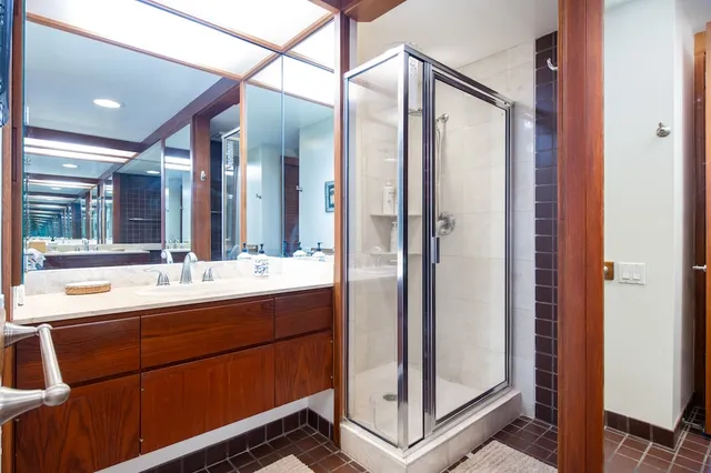 a bathroom with a double vanity sink mirror and shower