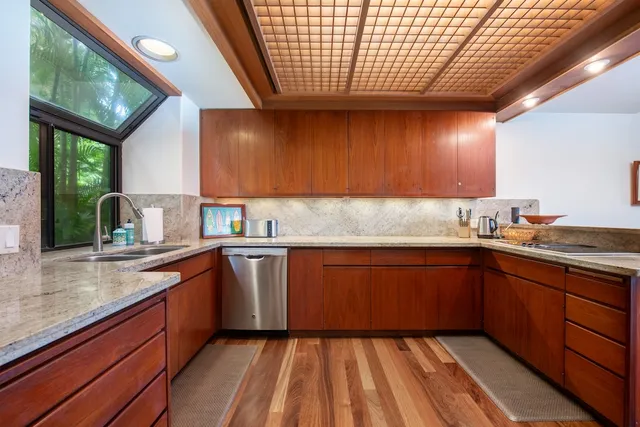 a kitchen with granite countertop wooden cabinets a sink and dishwasher