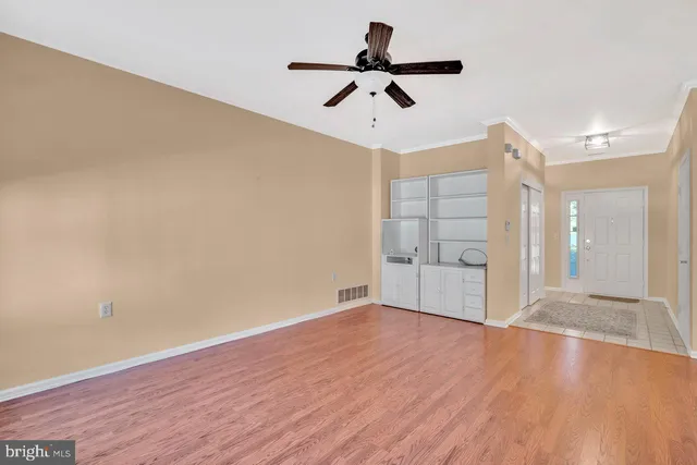 a view of empty room with wooden floor and window