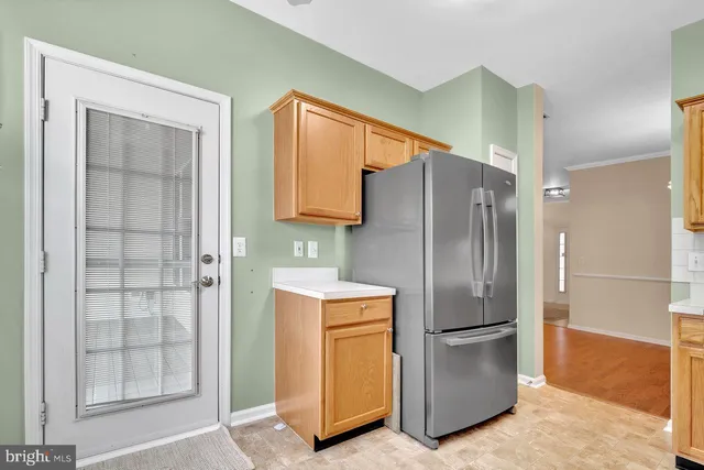 a metallic refrigerator freezer and a stove sitting inside of a kitchen