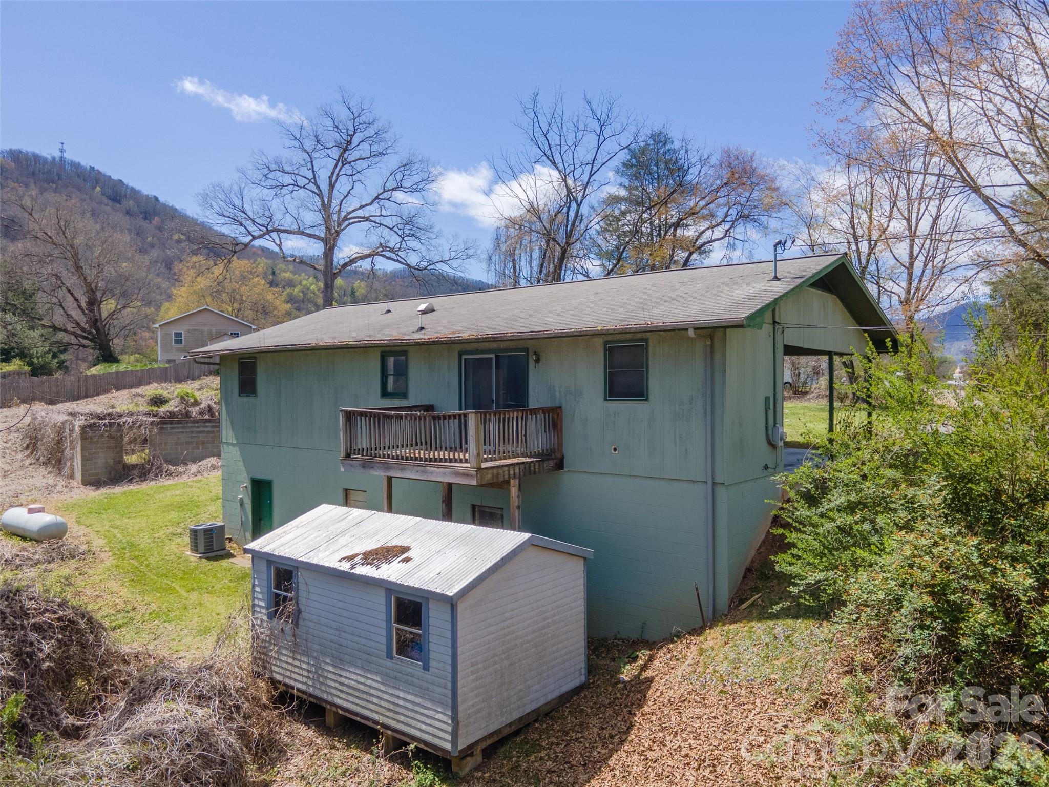 21 Queen Street Sylva, NC 28779 - Photo 32 of 45 a view of a house with a tub and trees in the background