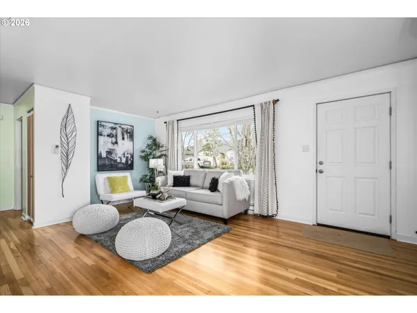 a living room with furniture potted plant and a large window