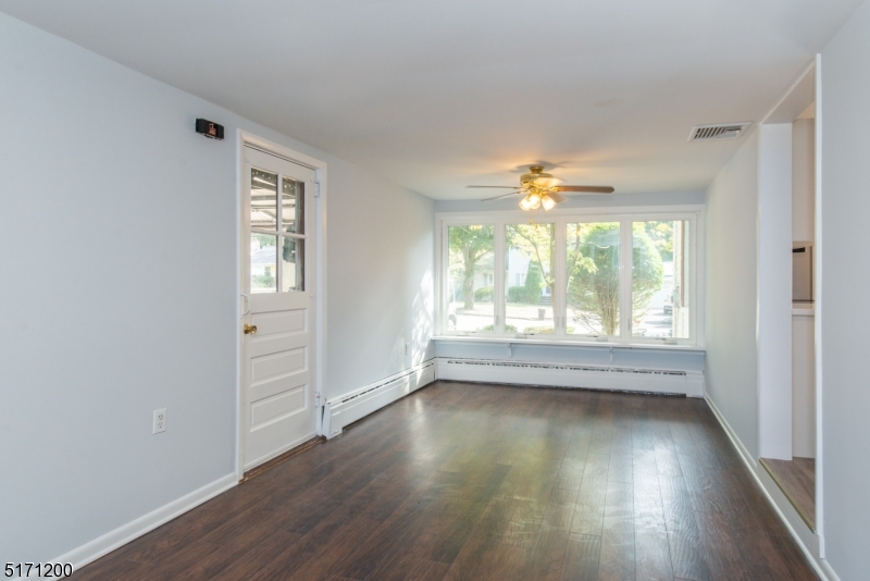 106 Fieldcrest Road Parsippany, NJ 07054 - Photo 11 of 18 an empty room with wooden floor and windows