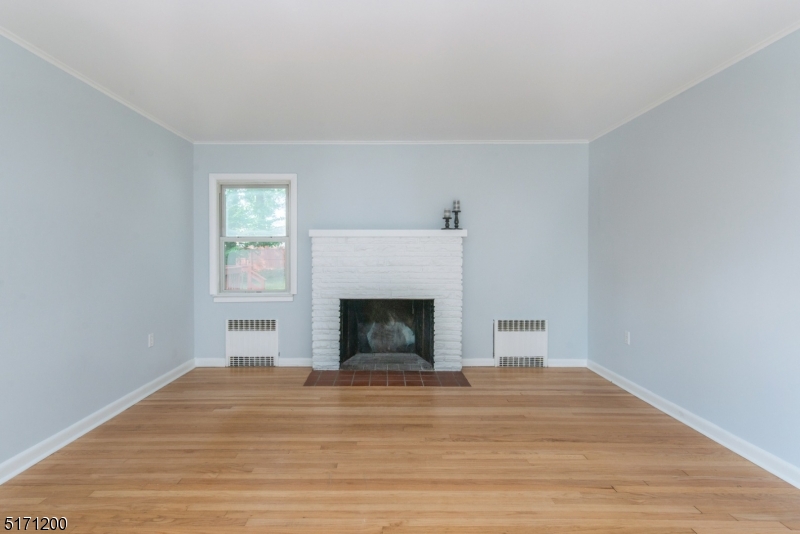 106 Fieldcrest Road Parsippany, NJ 07054 - Photo 3 of 18 a view of empty room with wooden floor and fireplace