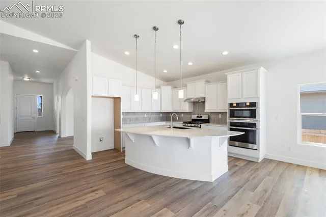 a kitchen with stainless steel appliances a refrigerator and a stove top oven