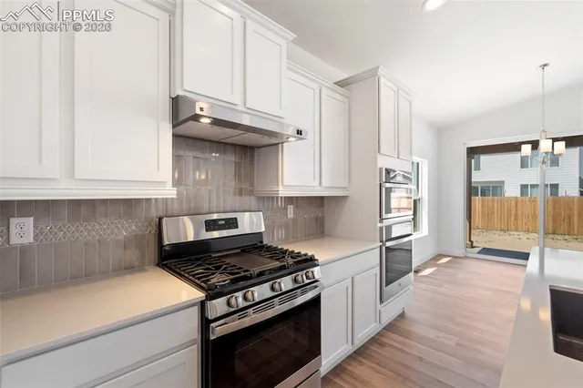 a kitchen with granite countertop a stove and a refrigerator