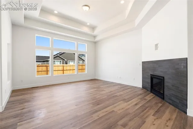 a view of empty room with wooden floor and fireplace