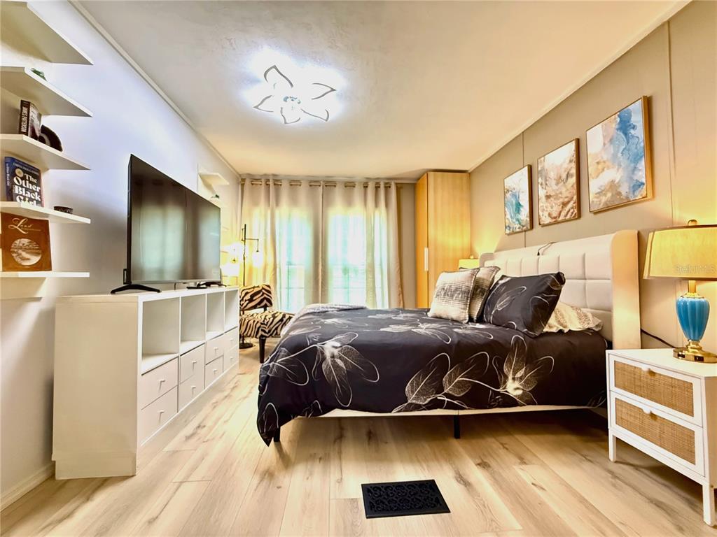 208 Ashley Street Hawthorne, FL 32640 - Photo 17 of 32 a living room with a bed and a flat tv screen on dresser