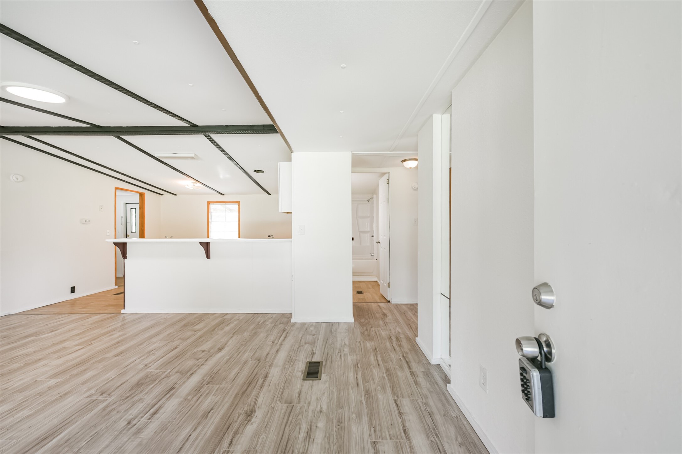 a view of a hallway with wooden floor and staircase