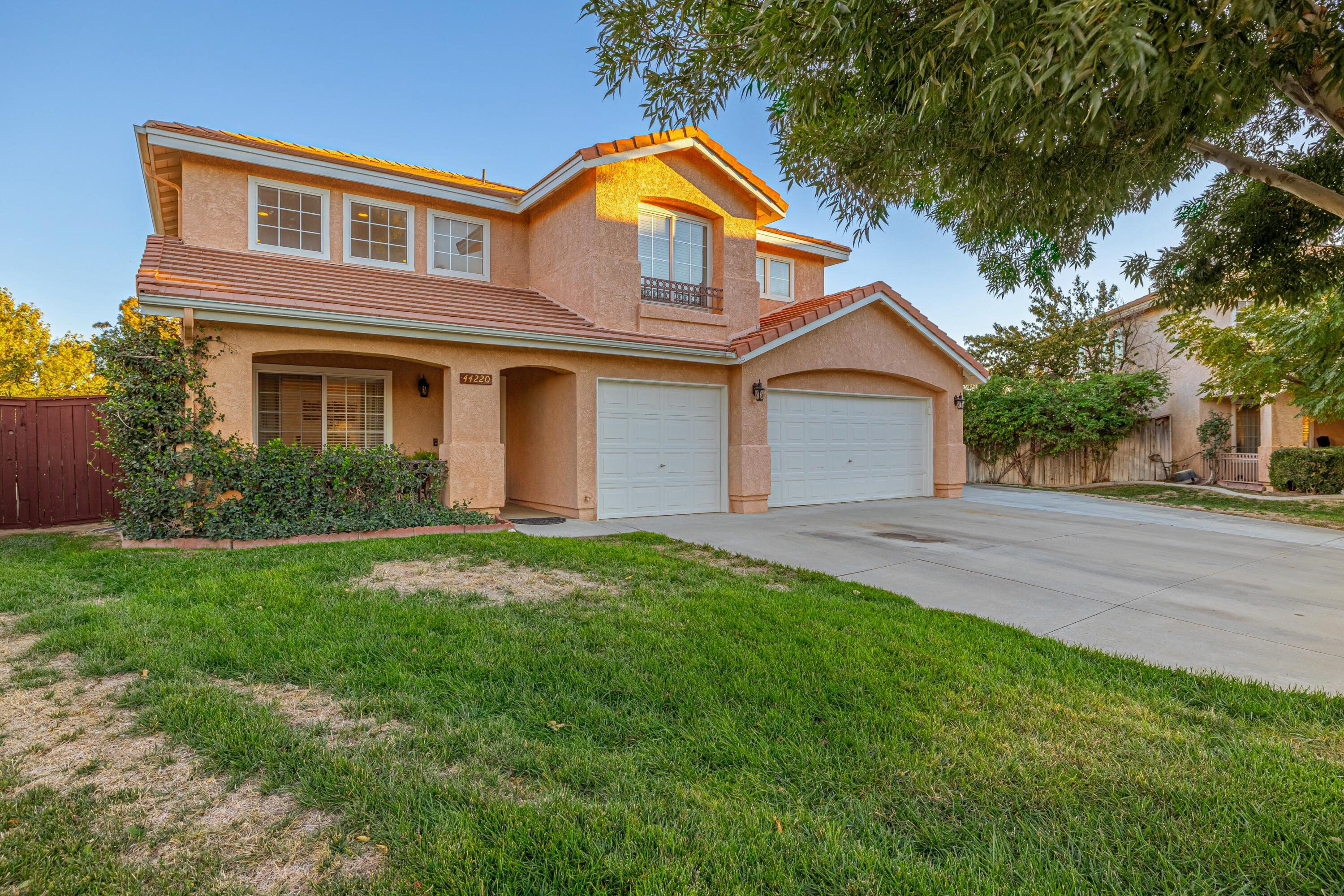 44220 Encanto Way Lancaster, CA 93536 - Photo 3 of 45 a front view of a house with a yard and garage