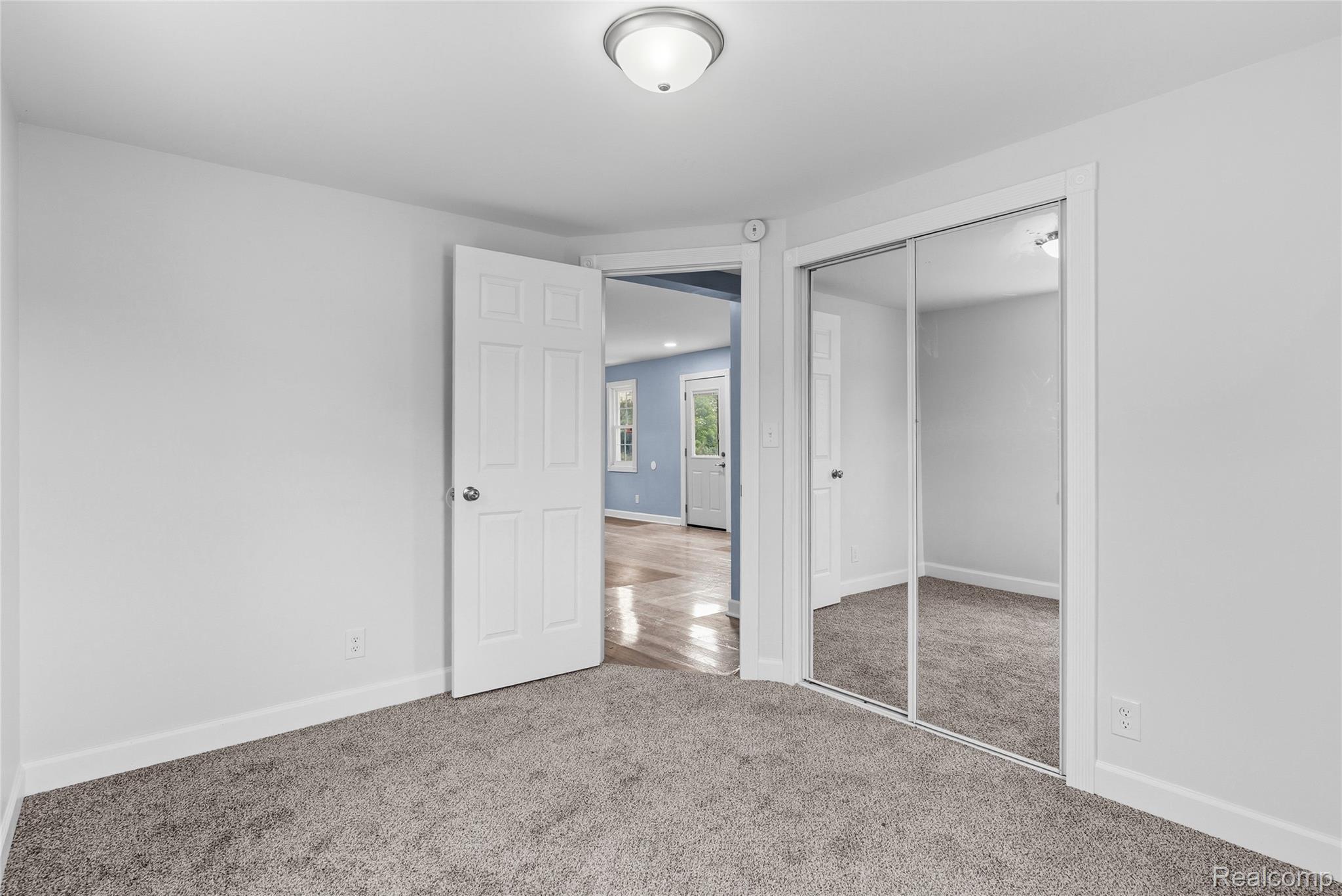 3241 East Frances Road Clio, MI 48420 - Photo 16 of 32 Carpeted room with white walls, a flush mount ceiling light, and a two-panel door