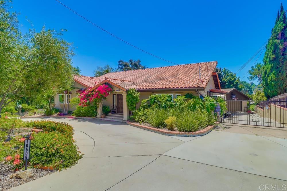 a view of a house with a yard and potted plants