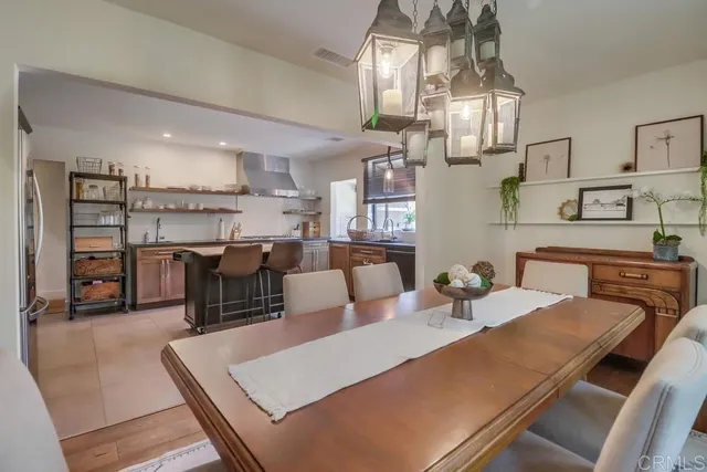 a kitchen with stainless steel appliances granite countertop a table chairs and a refrigerator