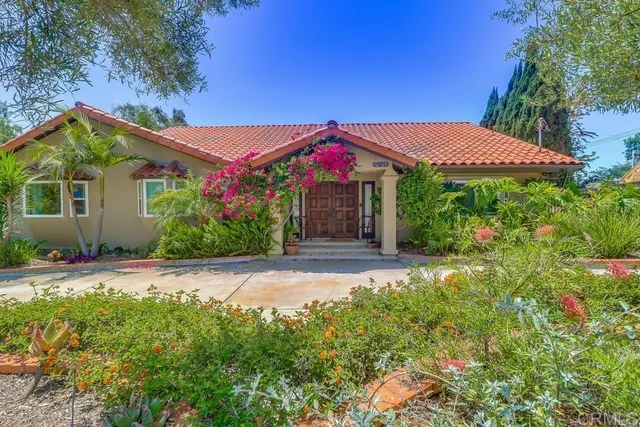 a front view of a house with plants
