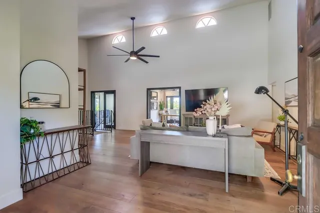 a living room with furniture kitchen view and a large window