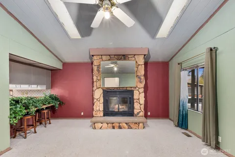 an empty room with windows and fireplace