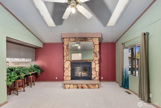 an empty room with windows and fireplace