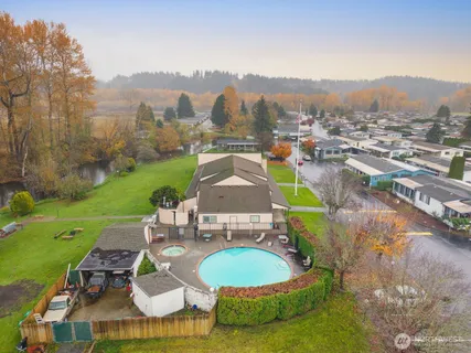 a white house with a big yard and large trees with a big yard