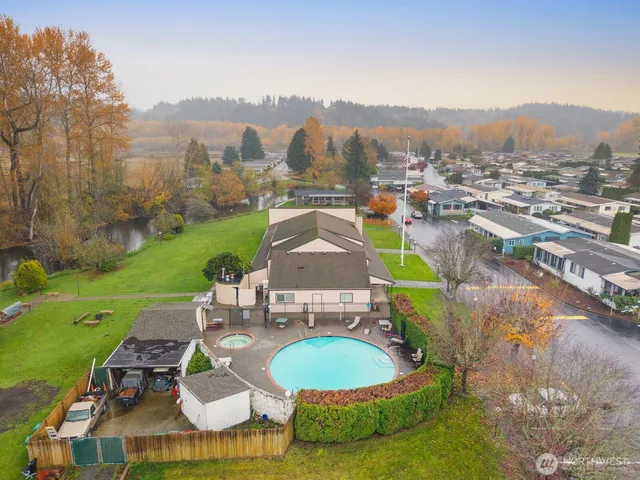 a white house with a big yard and large trees with a big yard