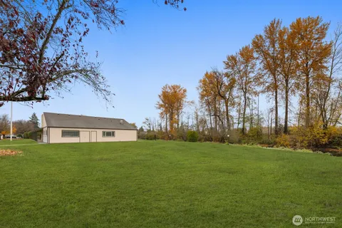 a view of a swimming pool with a yard and sitting area