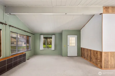 an empty room with floor to ceiling window and an outdoor view