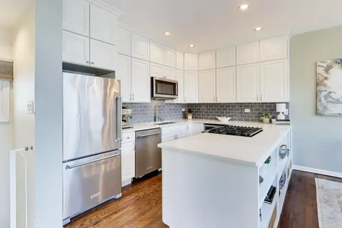 a kitchen with a refrigerator a stove top oven a sink and cabinets