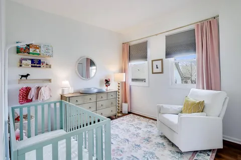 a living room with furniture and a baby crib