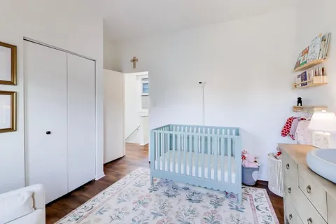 a bedroom with a bed and wooden floor