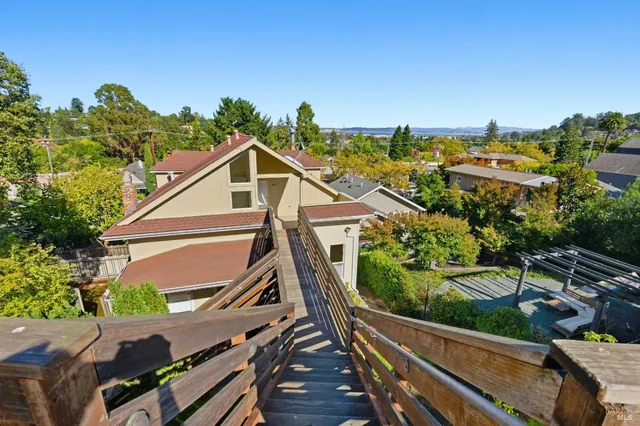 a view of a house with wooden deck and trees