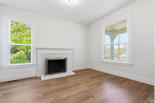 a kitchen with white cabinets and window