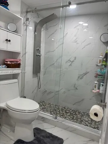 a bathroom with a toilet and a shower
