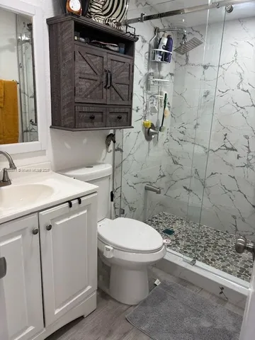a bathroom with a sink a toilet and shower