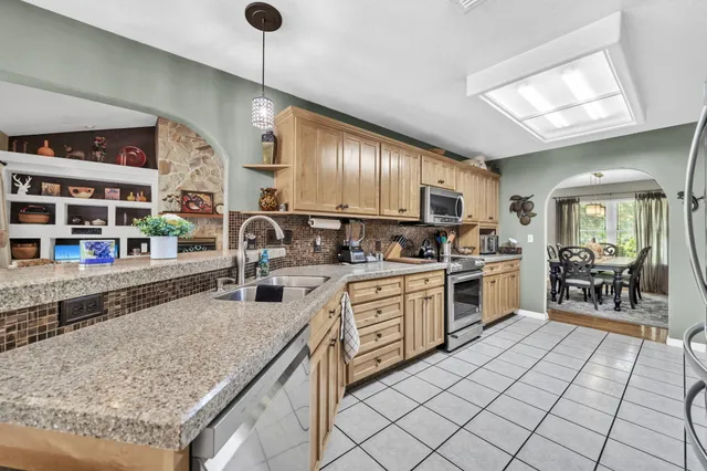 a kitchen with stainless steel appliances granite countertop a sink and cabinets
