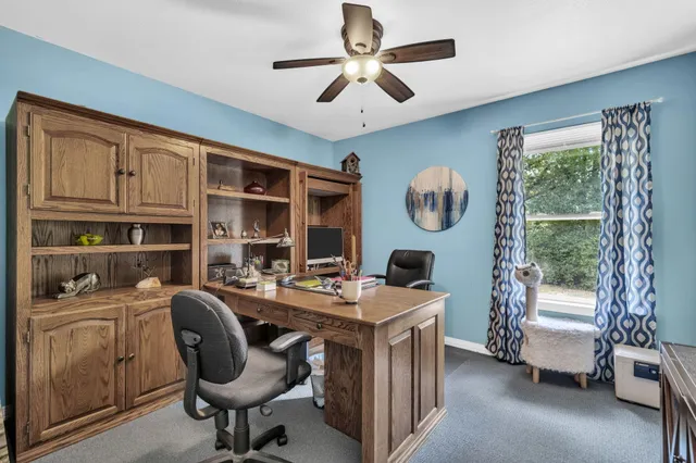 a view of a workspace with furniture and a window