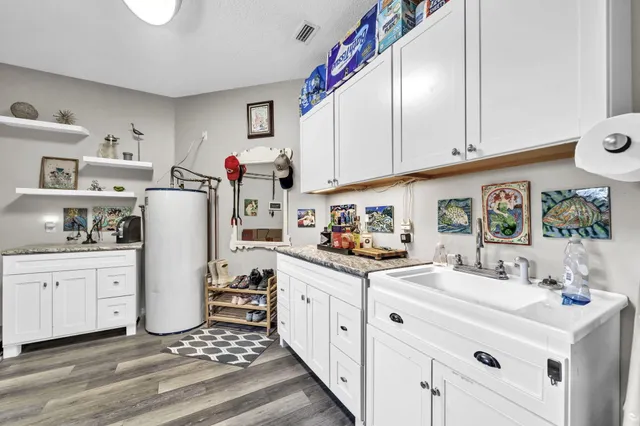 a view of a patio with table and chairs potted plants with wooden floor and fence